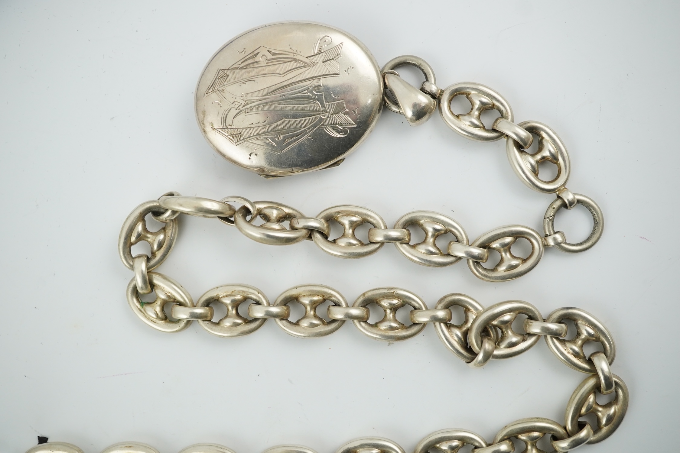 A late Victorian white metal oval locket with Japonaiserie decoration, 47mm, on a white metal chain. Condition - fair to good